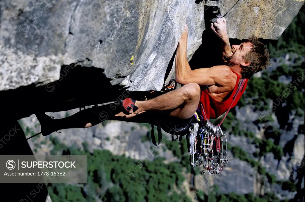 Male climber on an overhang high above a valley