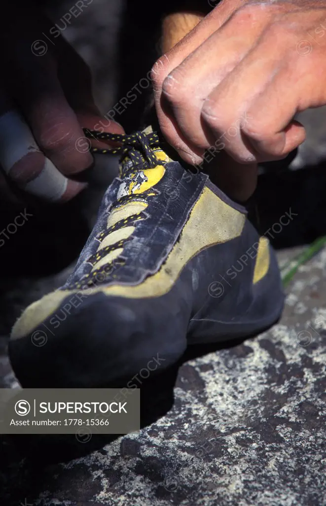 Hands tying a climbing shoe