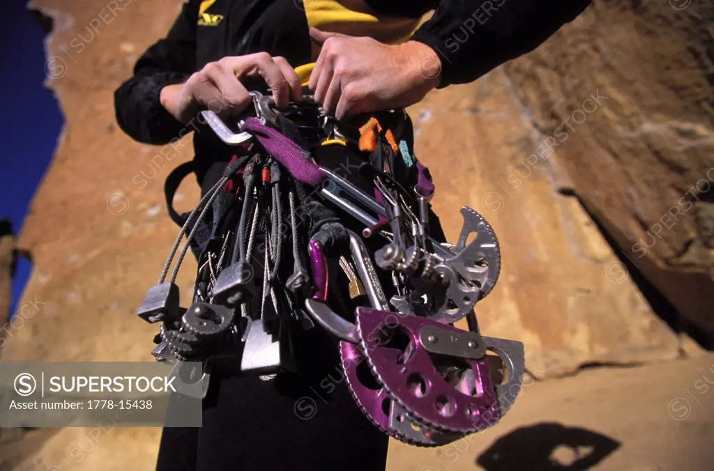 Climber's hands on a rack of cams