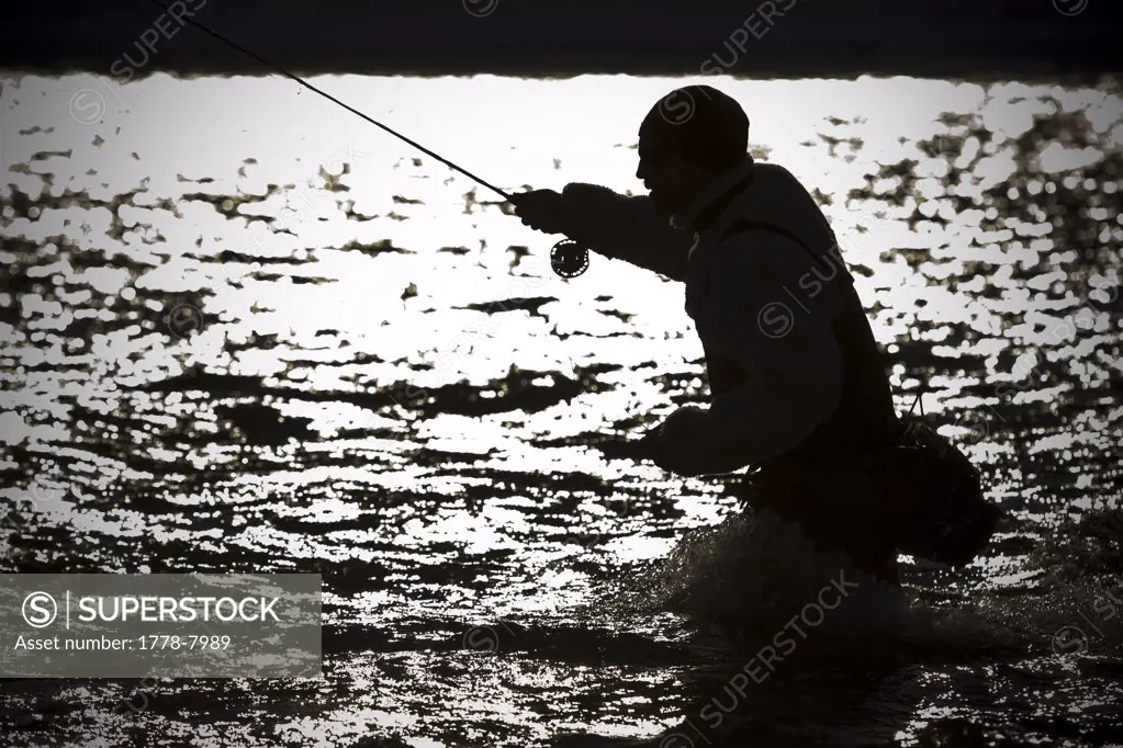 A man out fly fishing on a winter day