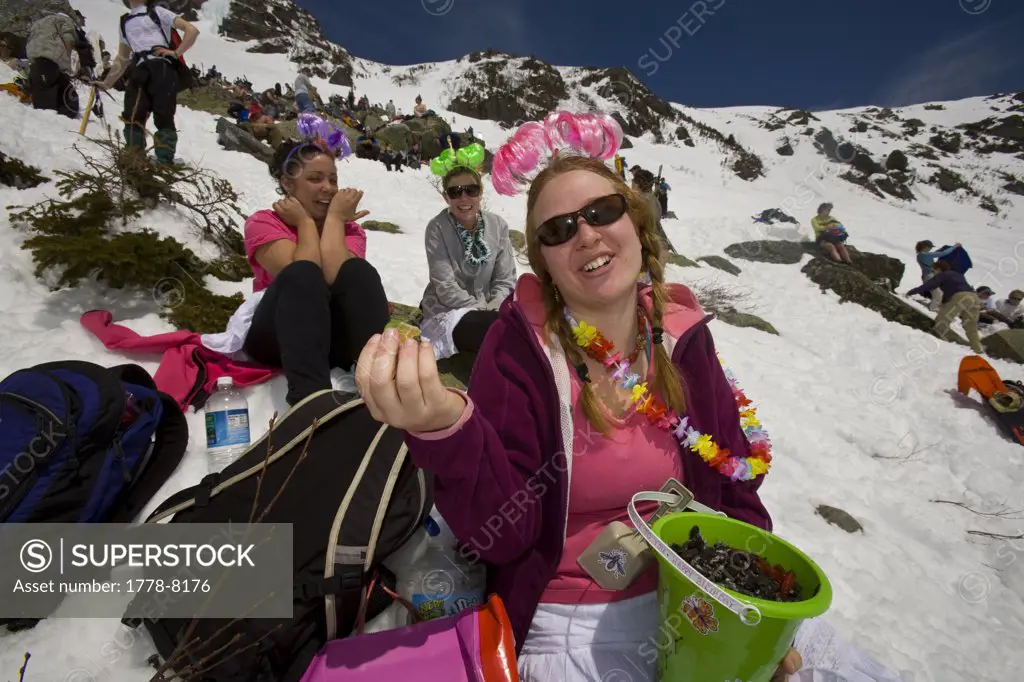 Skiers eat snacks while resting on Tuckerman Ravine on Mount Washington in the White Mountains of New Hampshire