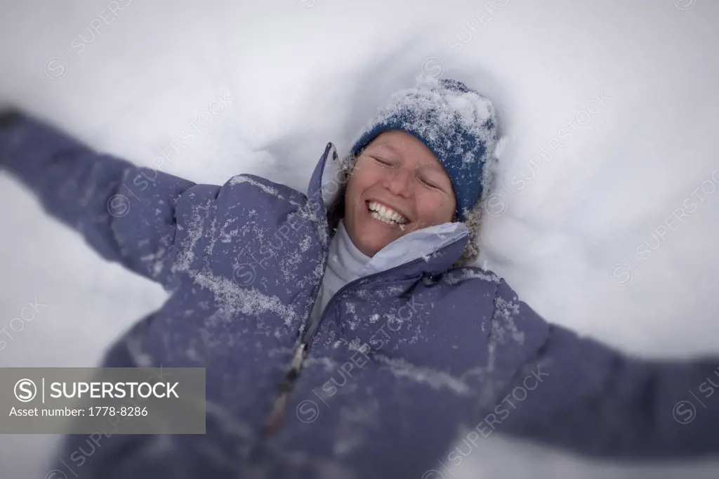 Kriste Lyon making a snow angel during big snowfall, Crested Butte, Colorado