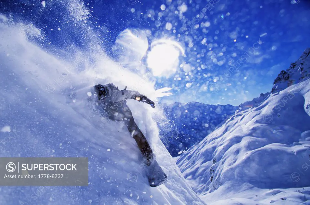 Man snowboarding in Chamonix, France (snow spray) (back lit) (tight framing)