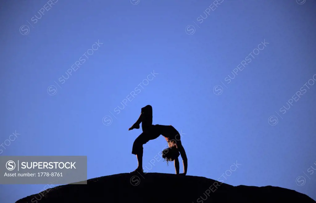 Woman doing yoga outside Pollen Grain Boulders, Bishop, California