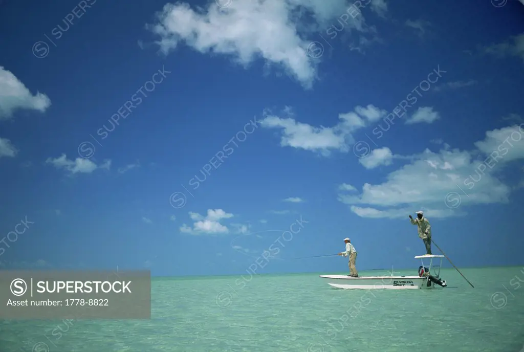 Two men fly-fish from a boat in the Bahamas