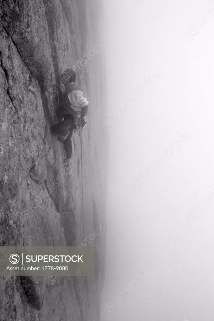 Man climbing rock face in the mist on the Diamond, Long's Peak, Rocky Mountain National Park, Colorado