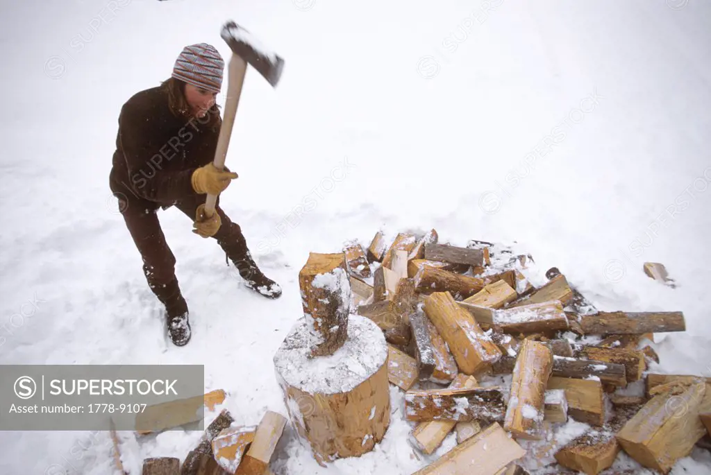 A woman splits logs for firewood, Jackson Hole, Wyoming (blurred motion)