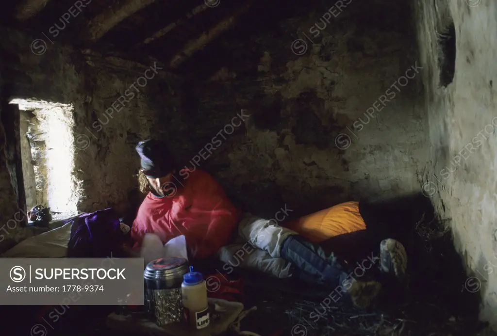 A trekker cooks in a hut high in the Indian, Himalaya