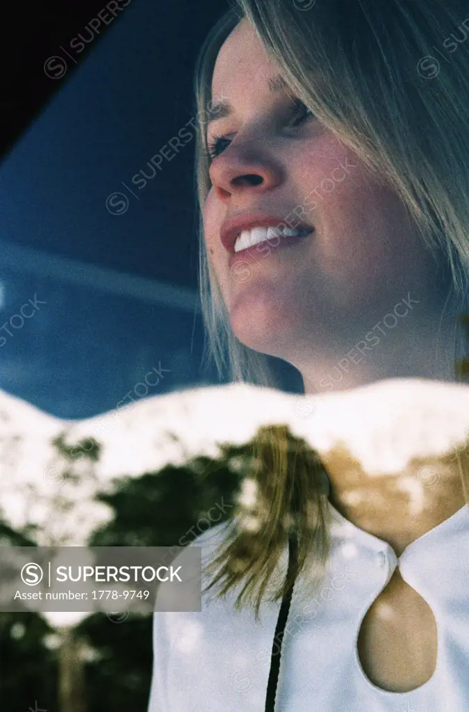 A young woman is seen in the window of  a mountain lodge (Grainy)