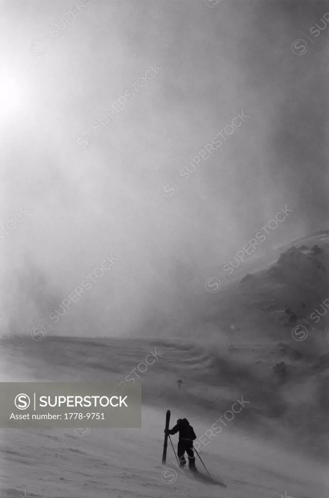 Skier hikes into an impending storm