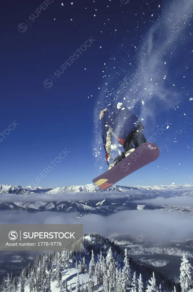 Snowboared jumping from cliff