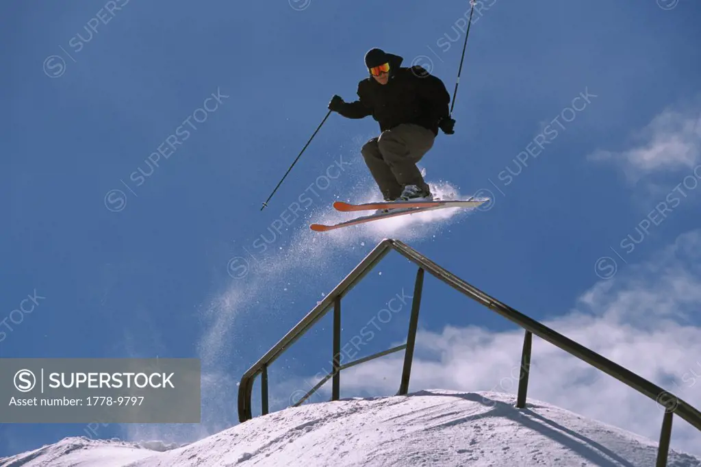 A skier does a trick on a handrail