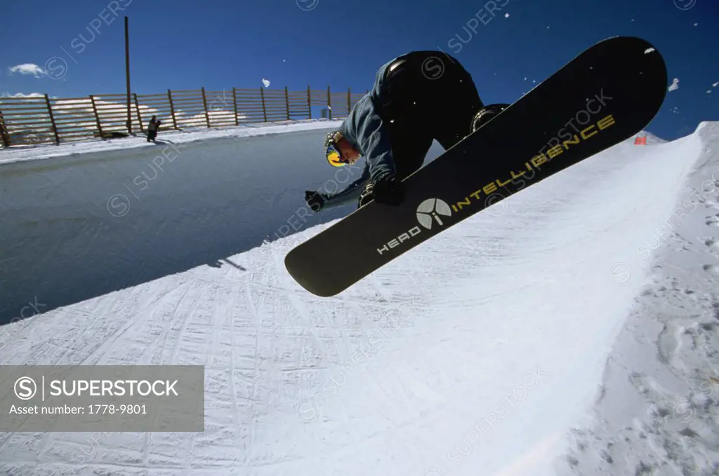 Snowboarder catches air in the half pipe