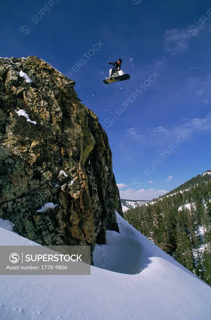 Big cliff launch by snowboarder