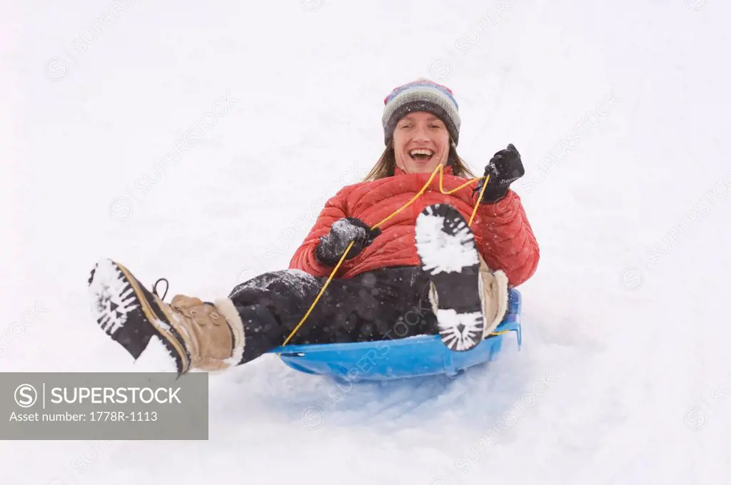 A woman sledding during snowstorm.