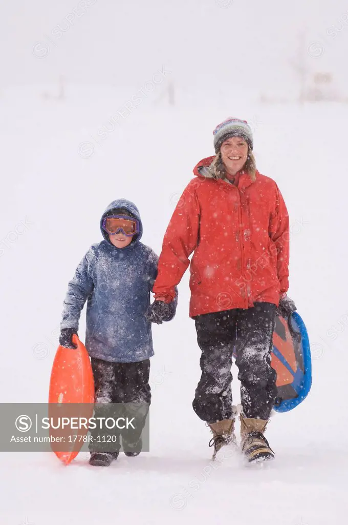 Mother and son sledding during snowstorm.