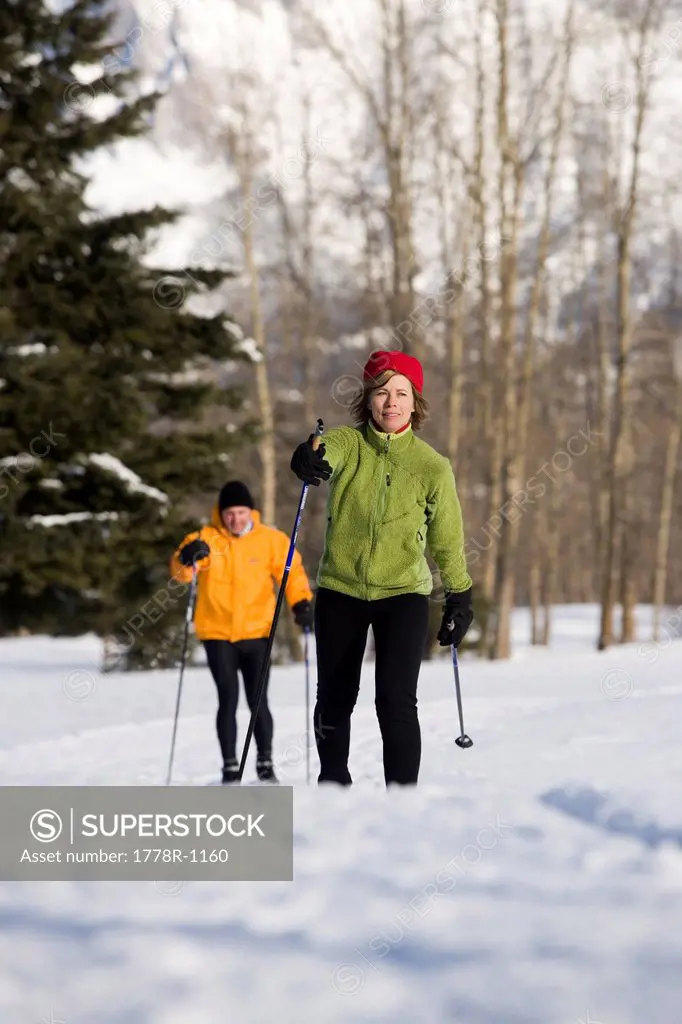 Couple cross_country skiing on groomed ski trails.