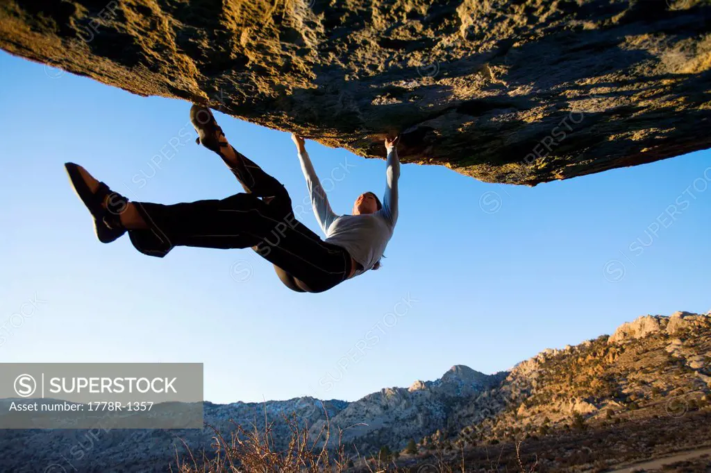 Woman bouldering on an overhang.