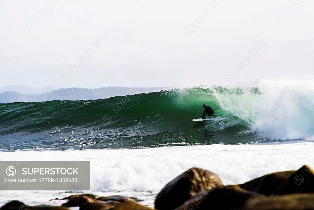 Surfer comes out of canadian barrel