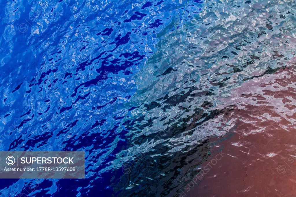 A view of the bulbous bow of a container ship underneath the surface of the ocean.