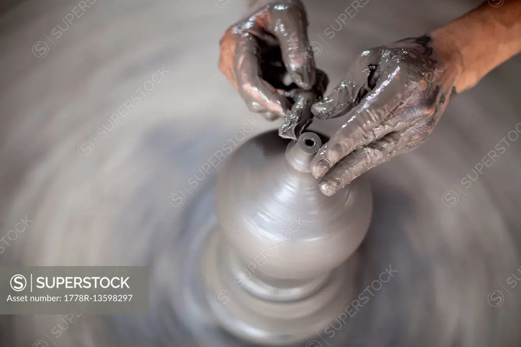 A potter's hands shapes a vessel to hold water in Nepal.
