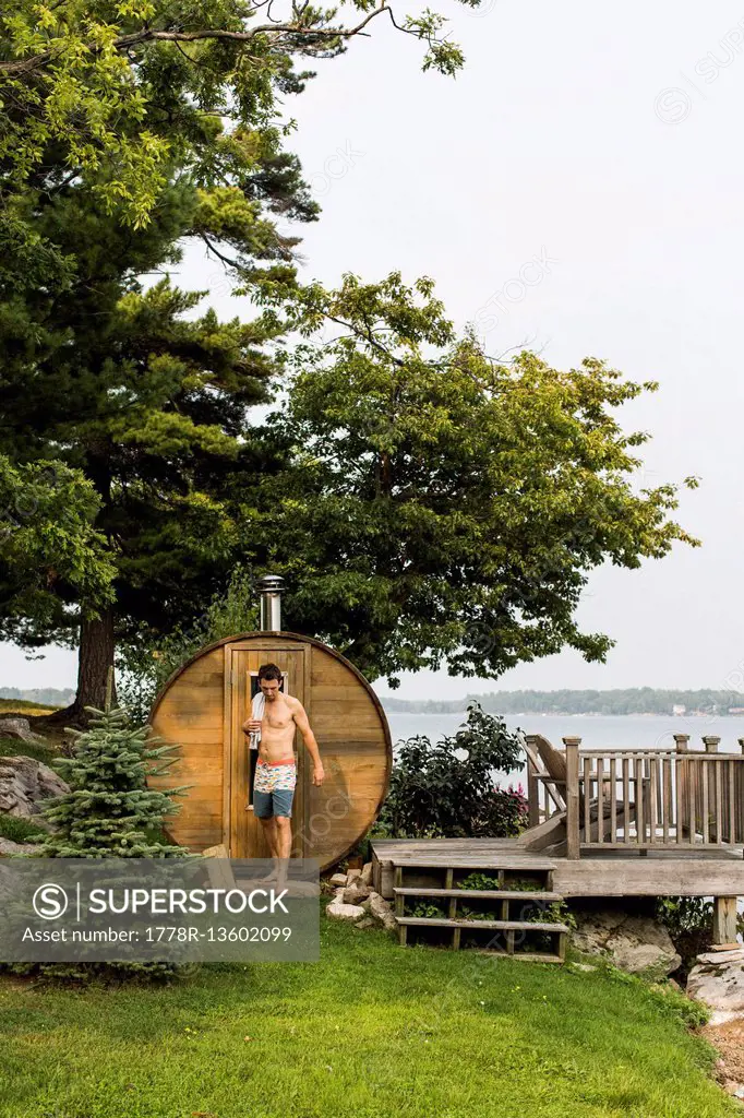 A Man Standing Next To A Backyard Sauna Along The Saint Lawrence River