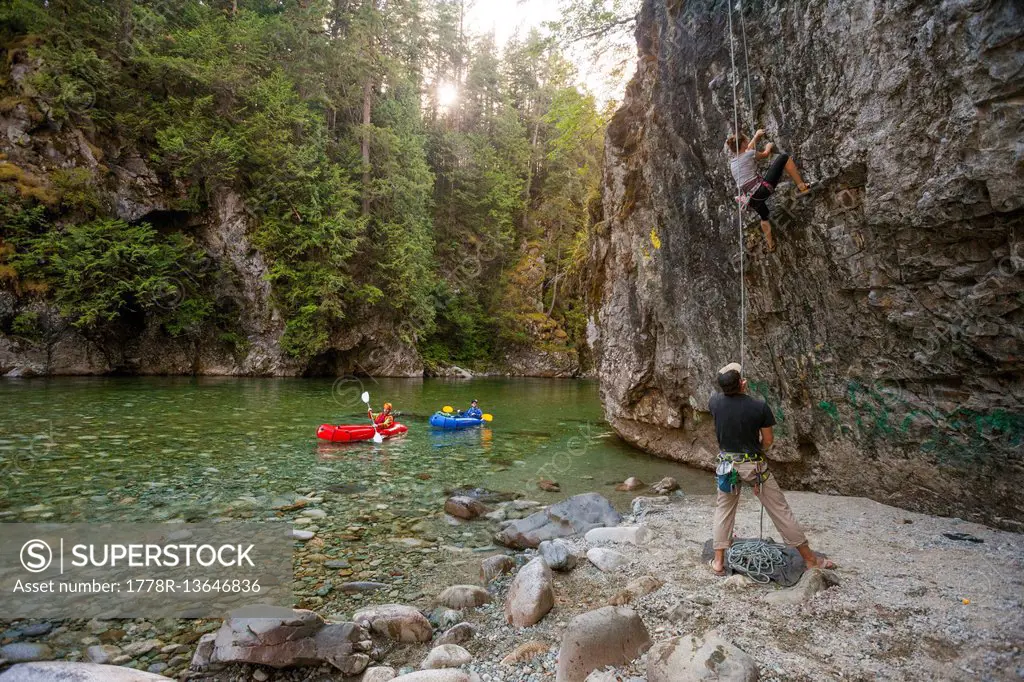 Two Packrafters Paddle The Chehalis River While Climbers Tackle A Rock Wall Beside The Chehalis River