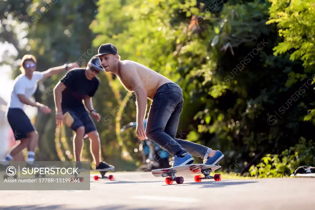 Young men skateboarding in street, Canggu, Bali, Indonesia