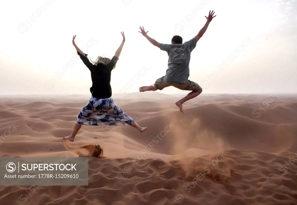 People jump in the Chegaga dunes in the Sahara desert in Morocco.
