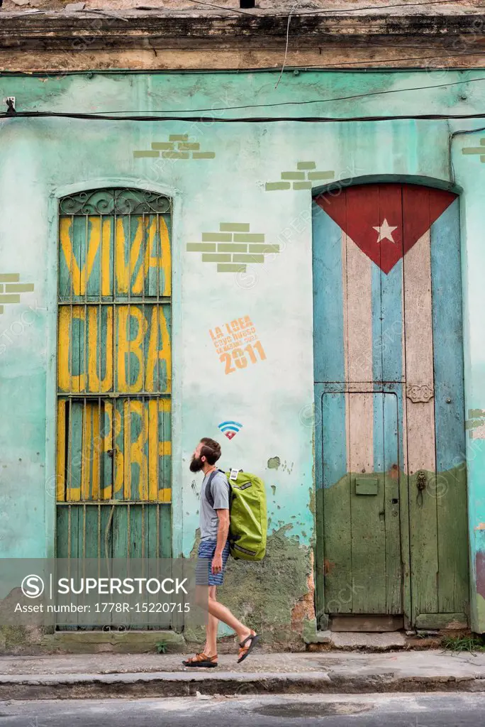 Side view of male tourist walking on street of Havana, Cuba
