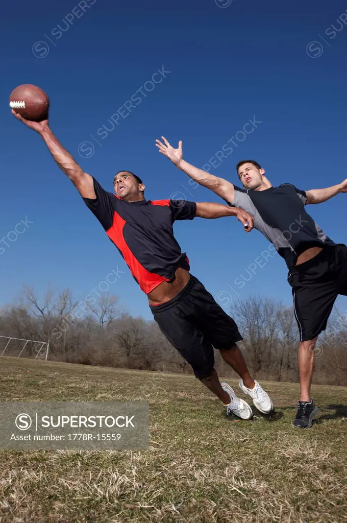 Two men compete for a pass in a touch football game.