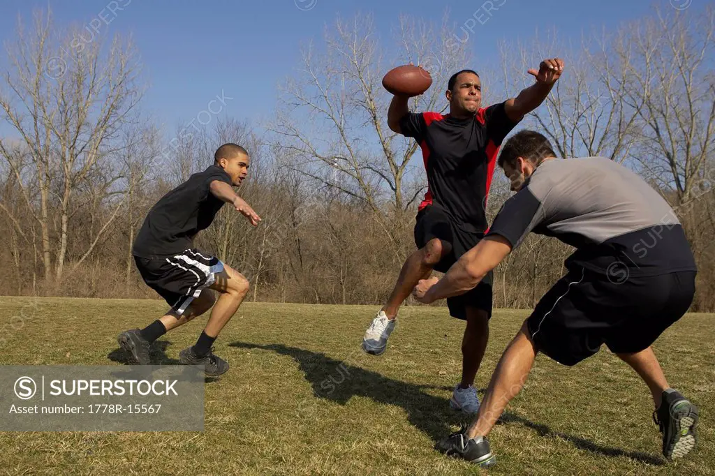 A quarterback is getting a pass off before he is sacked during a game of touch football.