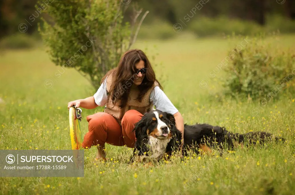 Women playing with her dog in the mountains.