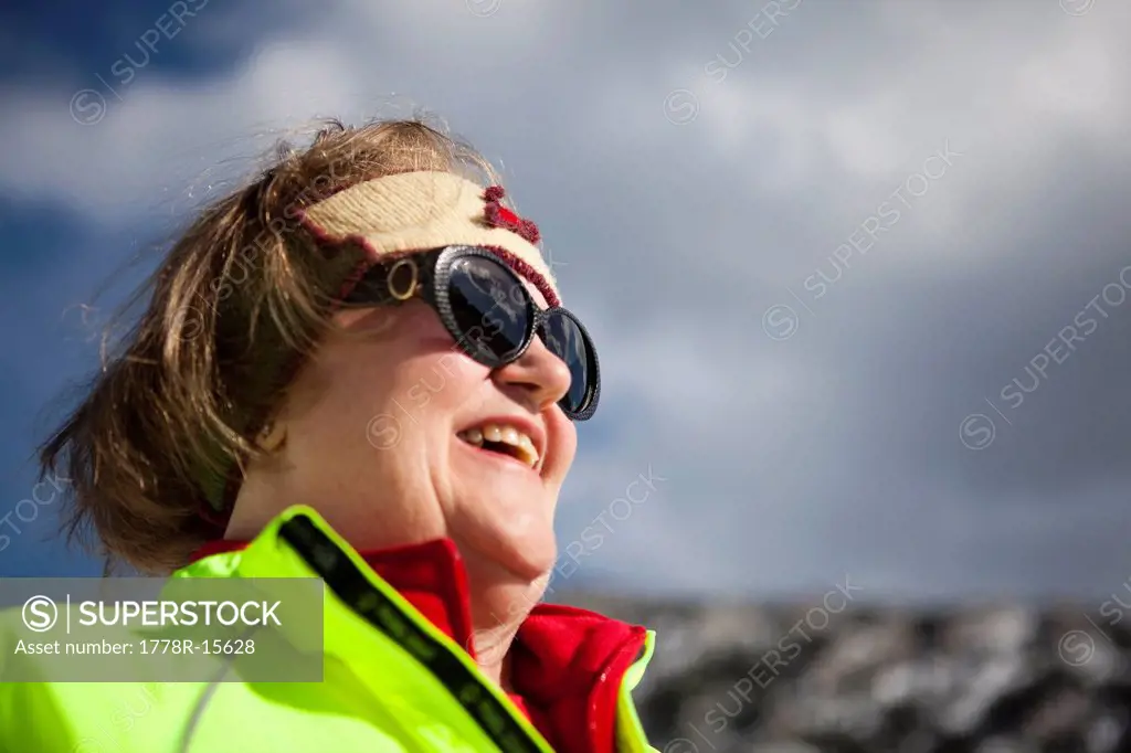 An active senior woman enjoys a blue sky winter day in the mountains of Colorado.