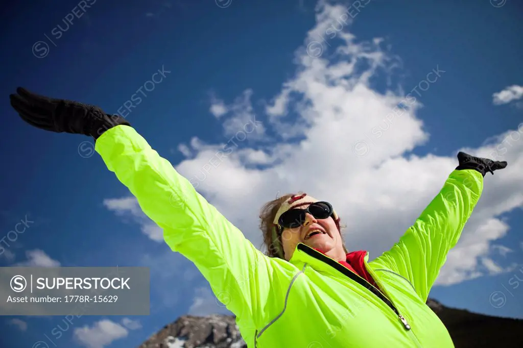 An active senior woman enjoys a blue sky winter day in the mountains of Colorado.