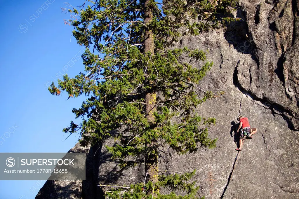 A male rock climber ascends a route in the traditional style, Lolo, Idaho.