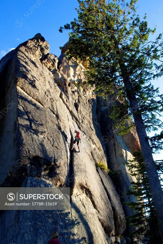 A male rock climber rappels after climbing a route in the traditional style, Lolo, Idaho.
