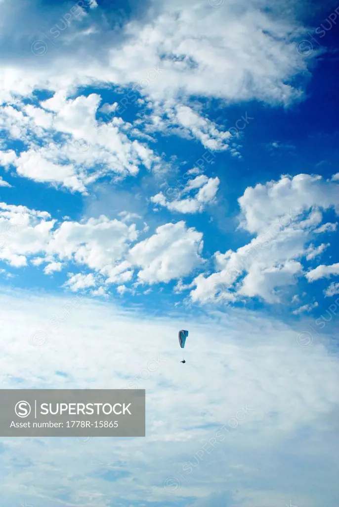Hang glider flies in the clouds over San Diego, California.