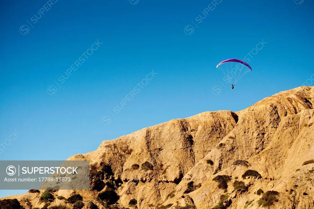 A hang glider floats above the cliffs of Torrey Pines over La Jolla, California.
