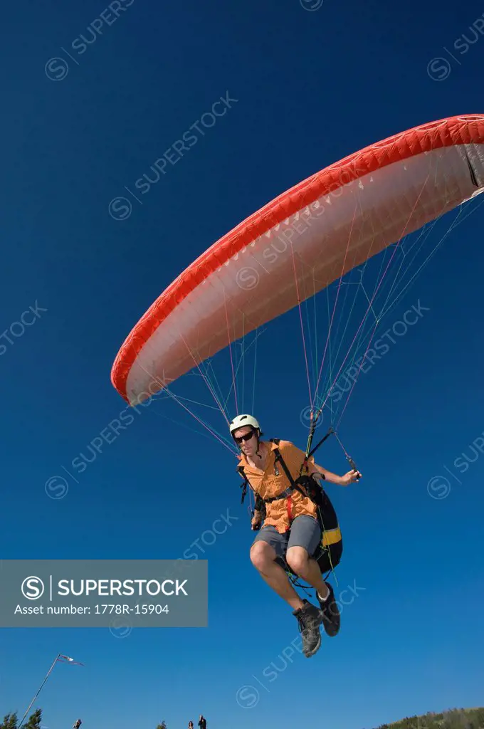 A paraglider lifts off the ground to begin his flight.