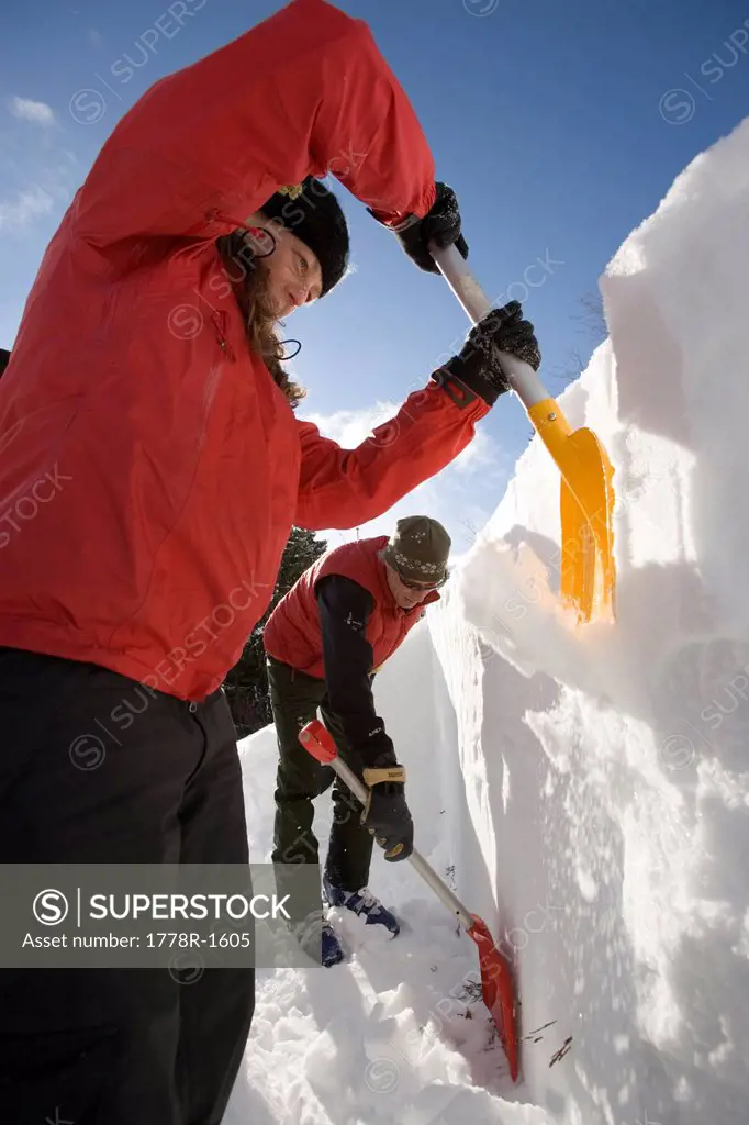 Backcountry skiers dig snow pit to check conditions.