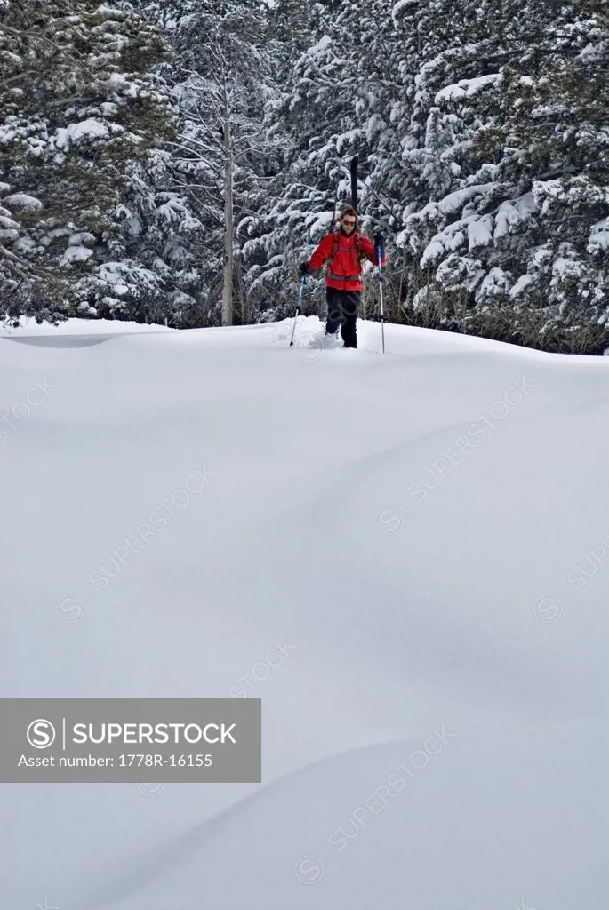 In search of fresh tracks, a young man hikes through knee_deep snow after a night of snowfall, in Lake Tahoe, Nevada.