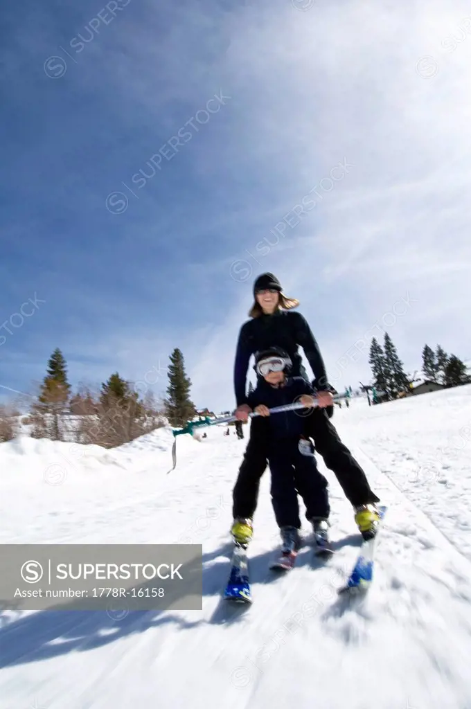 A young woman patiently teaches her nephew how to ski in Truckee, California.