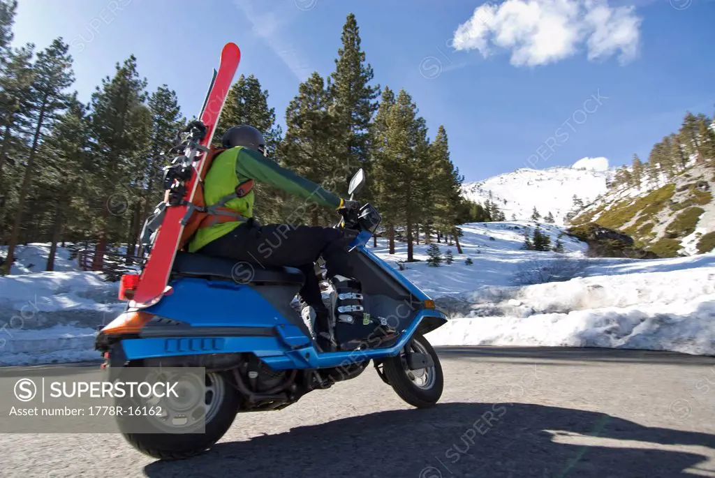 A young man rides a scooter to the start of the backcountry trail in Lake Tahoe, Nevada.