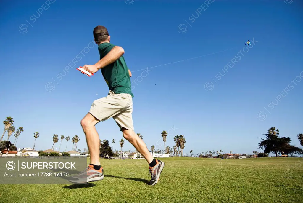 A young man flies a kite on a sunny California afternoon in Ventura, California.