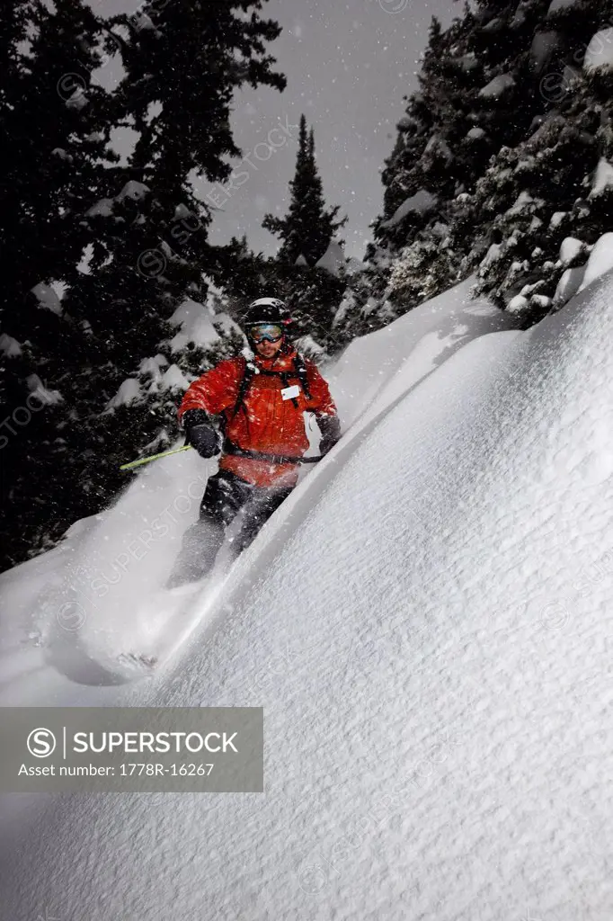 A male telemark skier charging untracked powder on a stormy day in Montana.