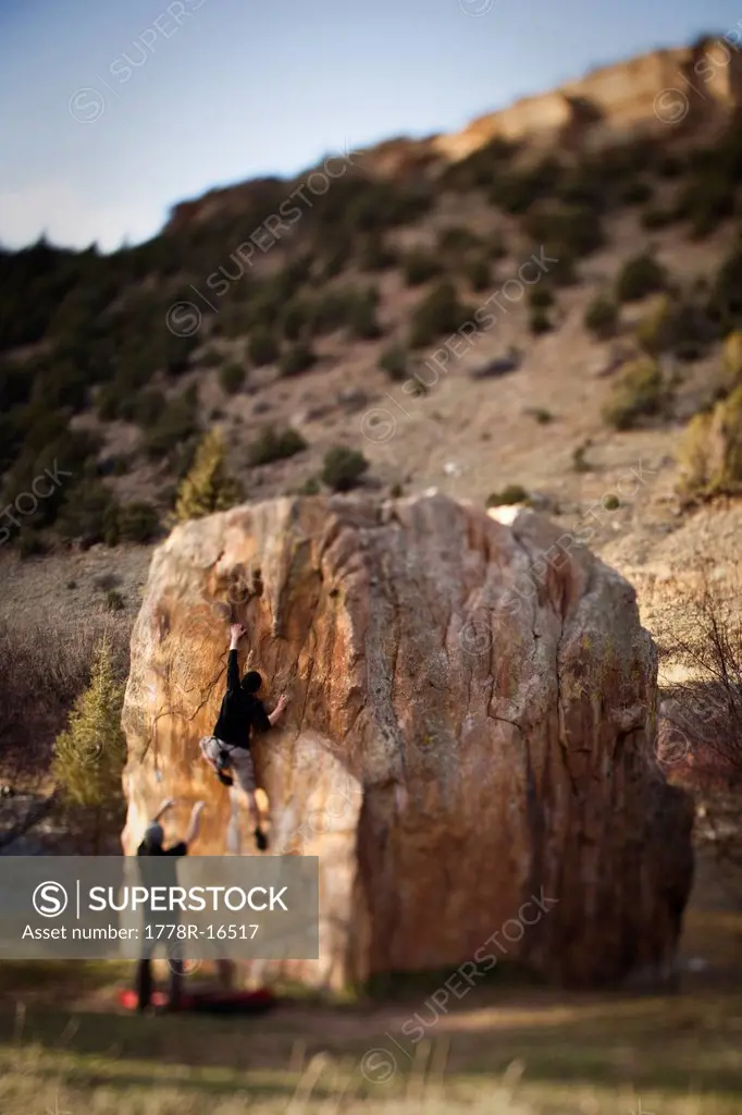 A rock climber works on bouldering problem in Colorado.