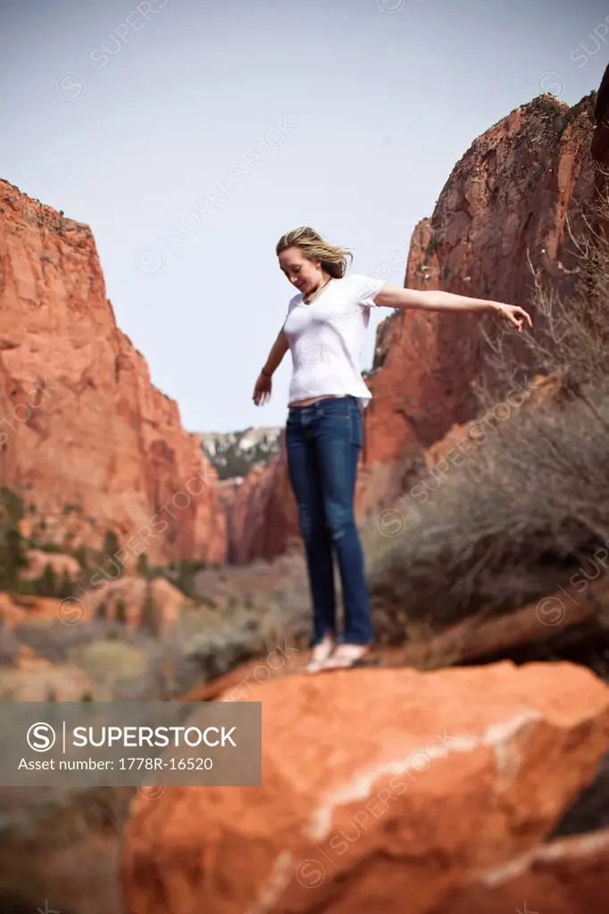A women balances on a rock in Utah.