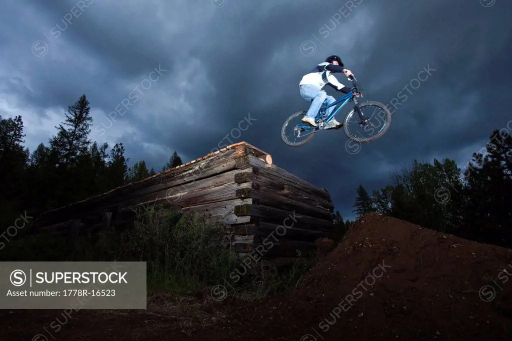 A mountain biker jumps off a log cabin in Idaho.