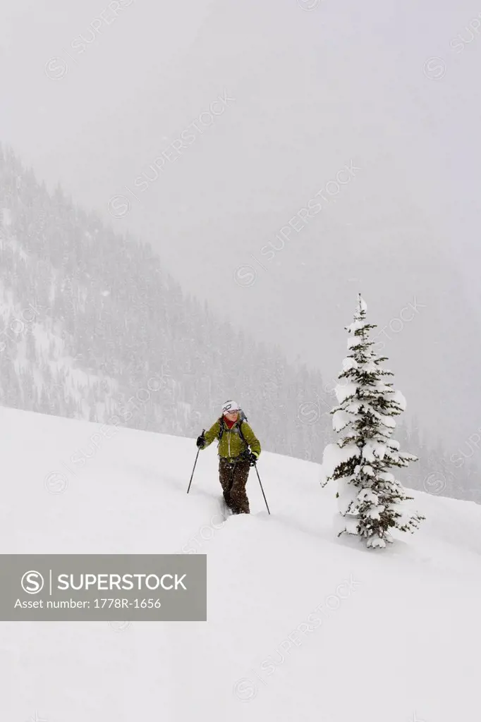 Young woman ski_touring through forest.